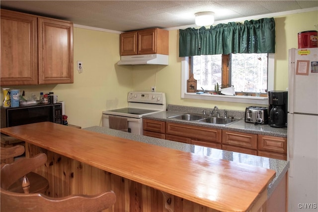 kitchen with wooden counters, a textured ceiling, white appliances, and sink