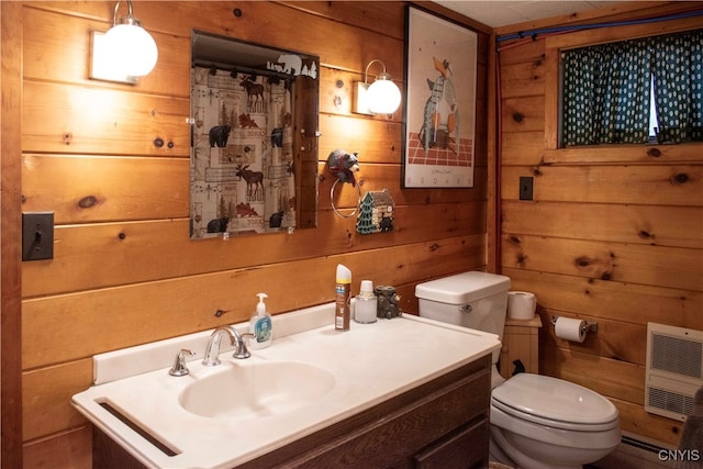 bathroom with vanity, toilet, wooden walls, and heating unit