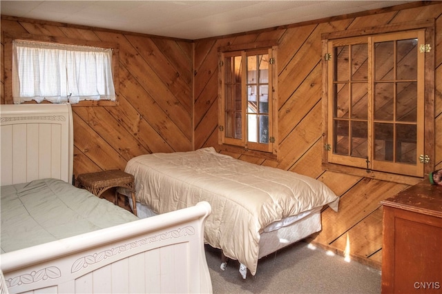 carpeted bedroom featuring wooden walls