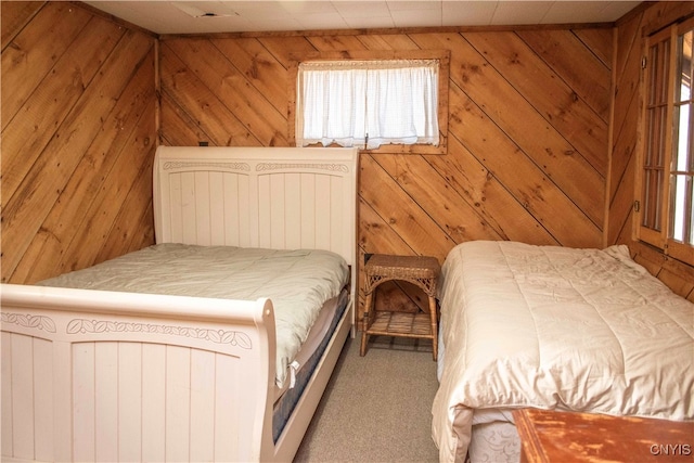 carpeted bedroom with wood walls