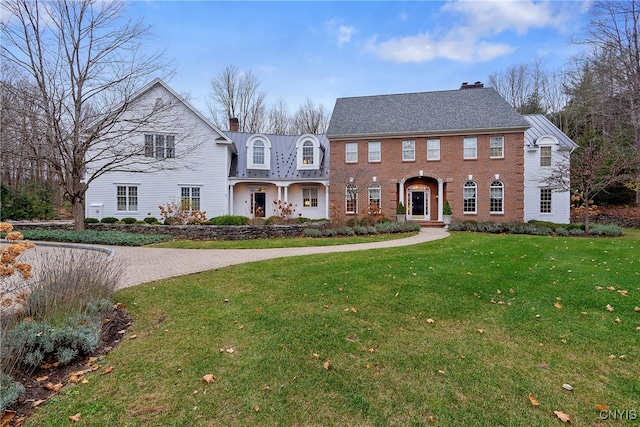 colonial-style house featuring a front yard