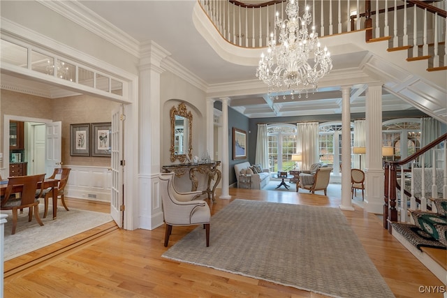 entrance foyer with ornate columns, crown molding, and hardwood / wood-style flooring