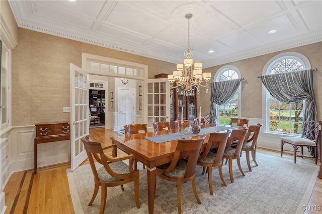 dining room featuring french doors, a chandelier, coffered ceiling, and light wood-type flooring