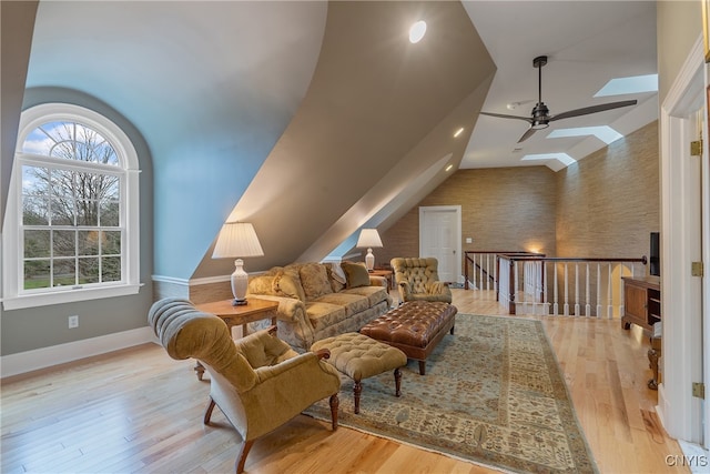 living area featuring light hardwood / wood-style floors, ceiling fan, and lofted ceiling