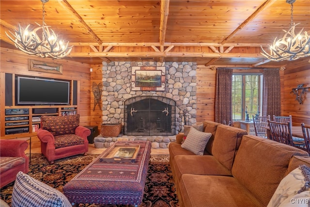 living room with beamed ceiling, a stone fireplace, wood ceiling, and an inviting chandelier