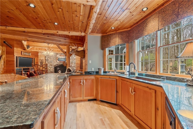 kitchen with lofted ceiling, dark stone countertops, light wood-type flooring, and wood ceiling