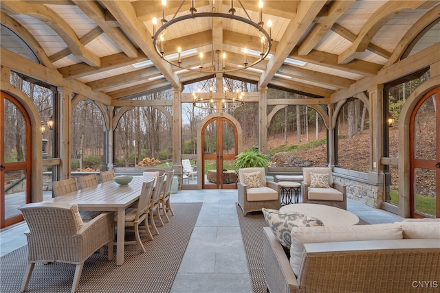 sunroom / solarium with lofted ceiling with beams, an inviting chandelier, and wooden ceiling