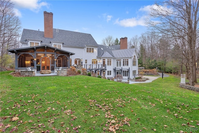 rear view of house featuring a lawn and area for grilling