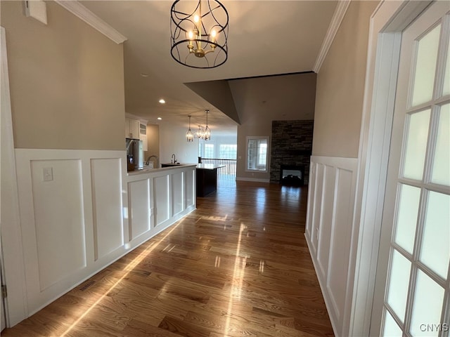 hall featuring dark hardwood / wood-style flooring, an inviting chandelier, ornamental molding, and sink