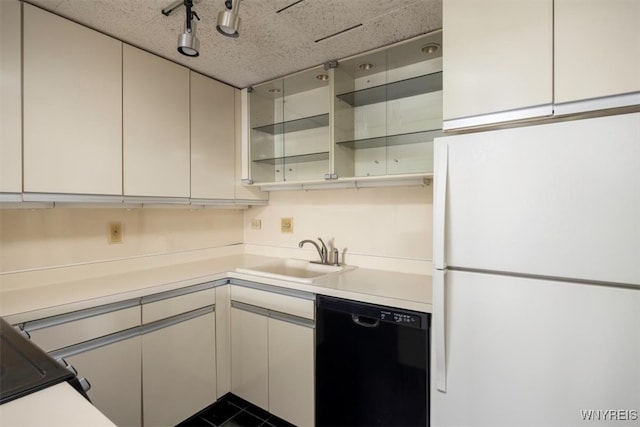 kitchen with rail lighting, sink, white refrigerator, black dishwasher, and white cabinetry