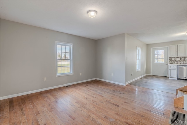 unfurnished living room with a wealth of natural light and light hardwood / wood-style floors