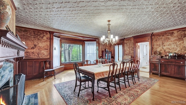 dining space featuring light wood-type flooring, a textured ceiling, and a chandelier