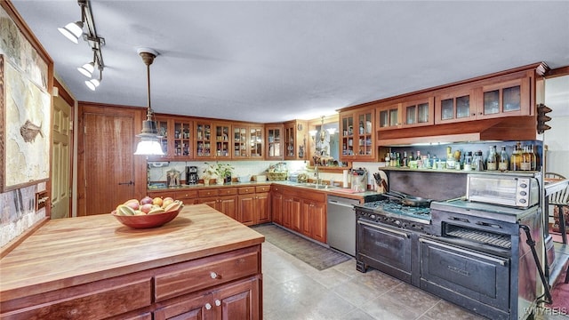 kitchen featuring pendant lighting, dishwasher, sink, rail lighting, and light tile patterned floors