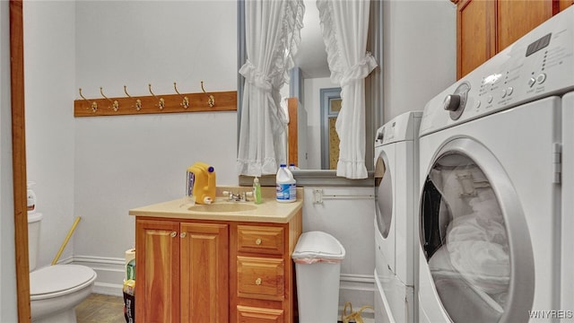 bathroom with washing machine and clothes dryer, tile patterned flooring, vanity, and toilet