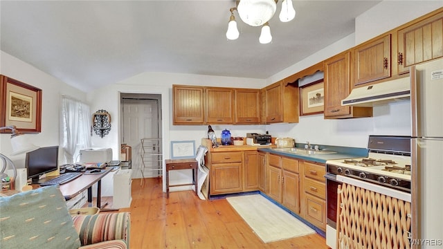 kitchen with a wealth of natural light, range with gas stovetop, a notable chandelier, and light hardwood / wood-style floors