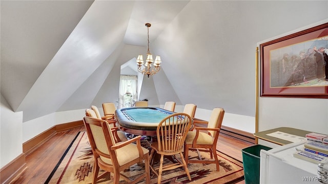 dining area featuring wood-type flooring, an inviting chandelier, and vaulted ceiling