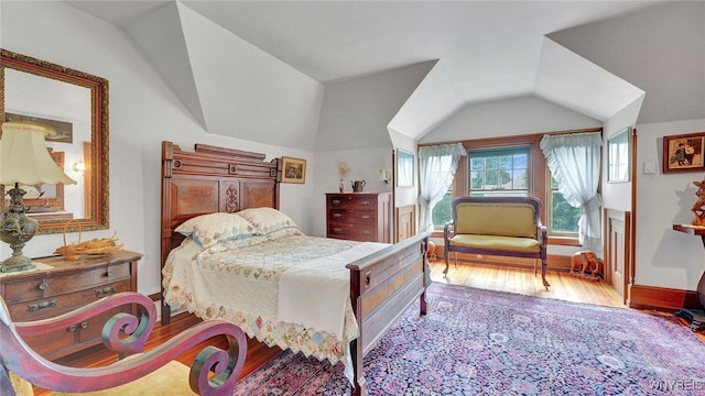 bedroom featuring light hardwood / wood-style floors and vaulted ceiling