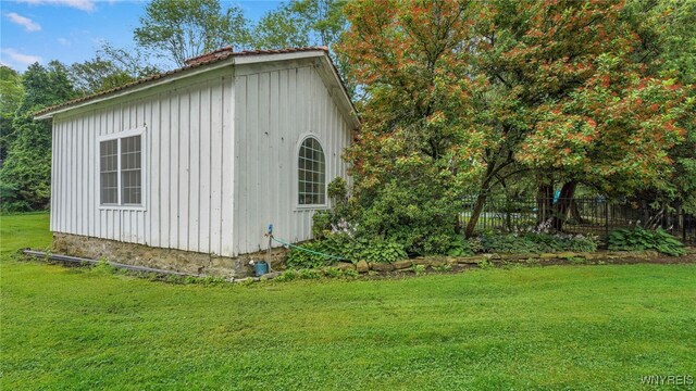 view of side of home with a lawn and a storage unit