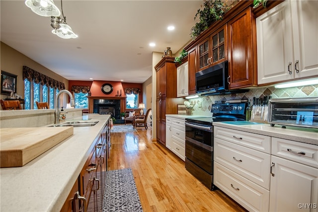 kitchen with appliances with stainless steel finishes, light hardwood / wood-style floors, plenty of natural light, and sink