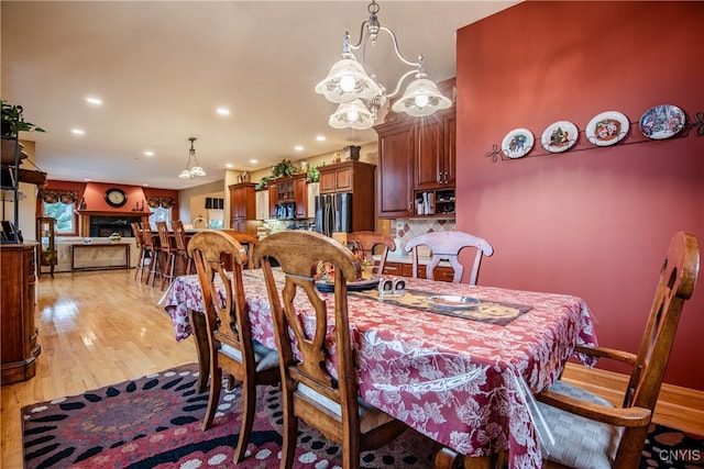 dining room with light hardwood / wood-style floors and a chandelier