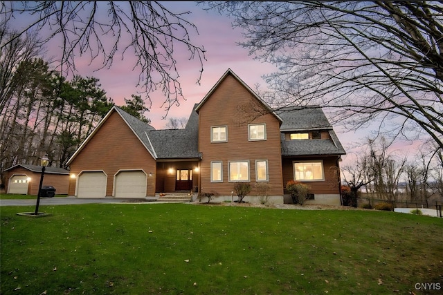 front of property with a lawn and a garage