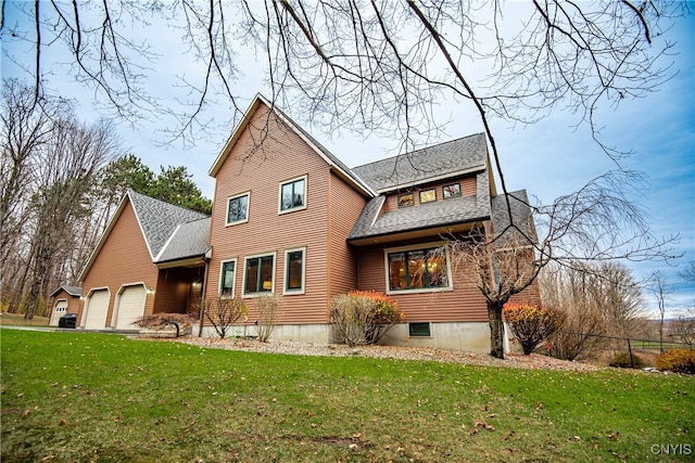 rear view of house featuring a garage and a lawn