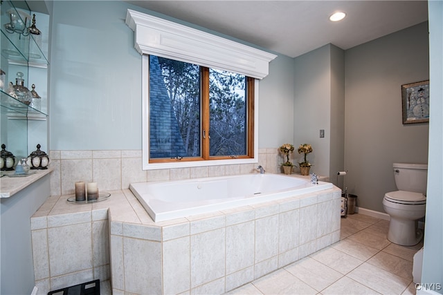 bathroom featuring tile patterned floors, a relaxing tiled tub, and toilet