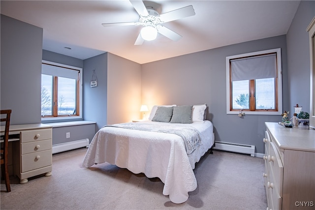 carpeted bedroom with ceiling fan and a baseboard heating unit