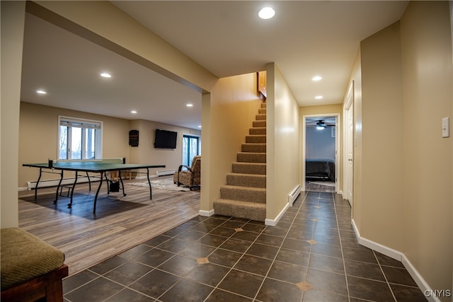 playroom featuring dark hardwood / wood-style floors, ceiling fan, and a baseboard radiator