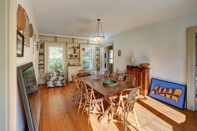 dining space featuring crown molding and light hardwood / wood-style floors