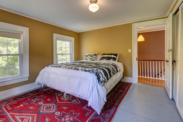 bedroom featuring hardwood / wood-style flooring, a closet, and crown molding