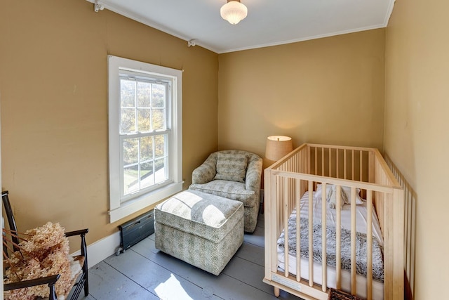 bedroom featuring a nursery area and crown molding