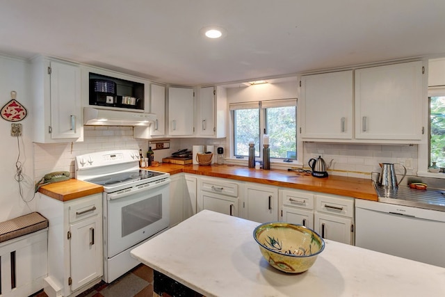 kitchen featuring butcher block countertops, backsplash, white cabinetry, and white appliances