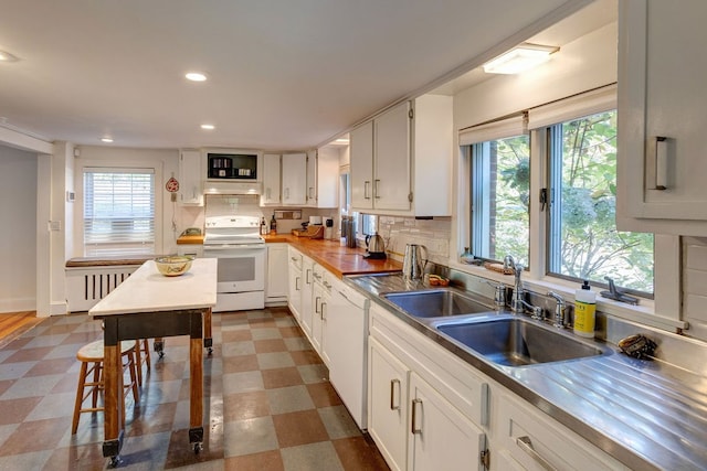 kitchen with white cabinets, white appliances, a wealth of natural light, and sink