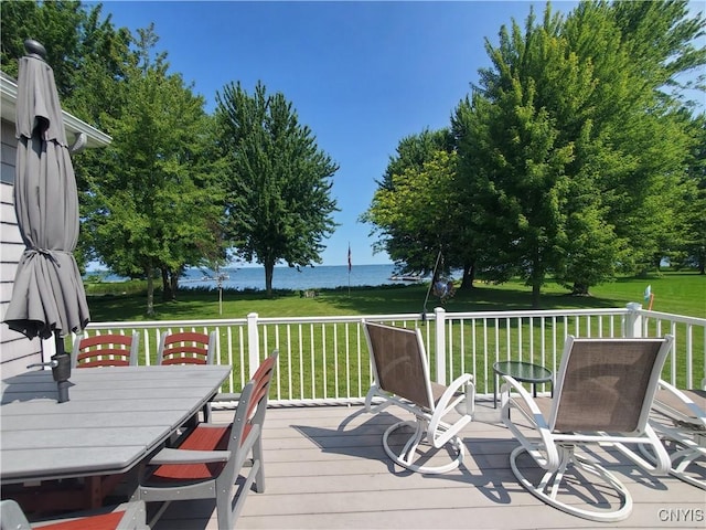 deck with a water view and a lawn