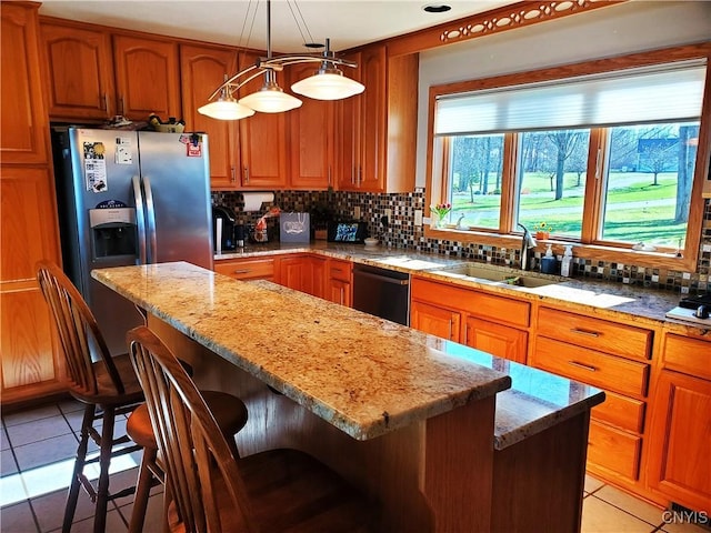 kitchen with dishwasher, decorative light fixtures, a kitchen island, and sink