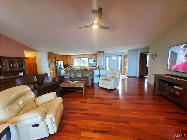 living room featuring ceiling fan, dark hardwood / wood-style flooring, and vaulted ceiling