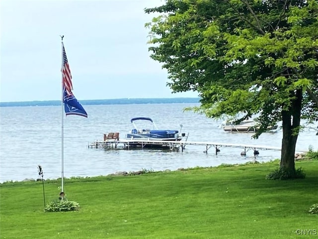 view of dock featuring a water view and a yard