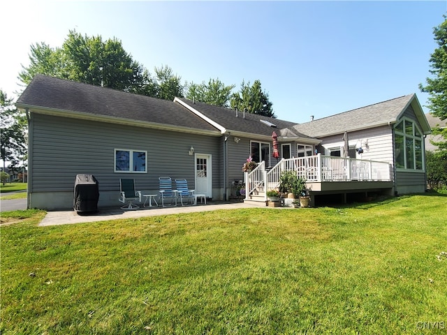 rear view of house with a lawn, a patio area, and a wooden deck