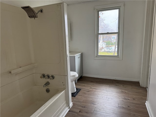 bathroom featuring wood-type flooring, toilet, and shower / washtub combination