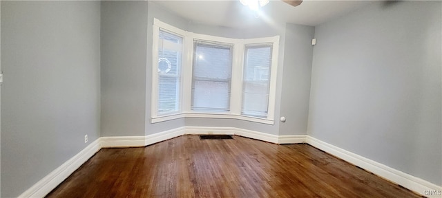 empty room with ceiling fan and hardwood / wood-style flooring