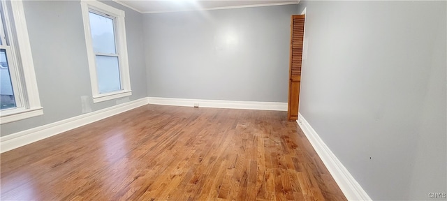 empty room with light hardwood / wood-style floors and crown molding