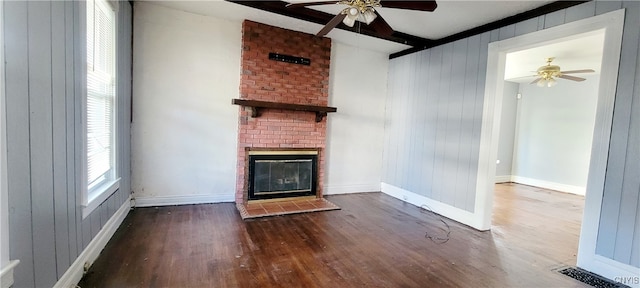 unfurnished living room with dark hardwood / wood-style floors, ceiling fan, and wooden walls