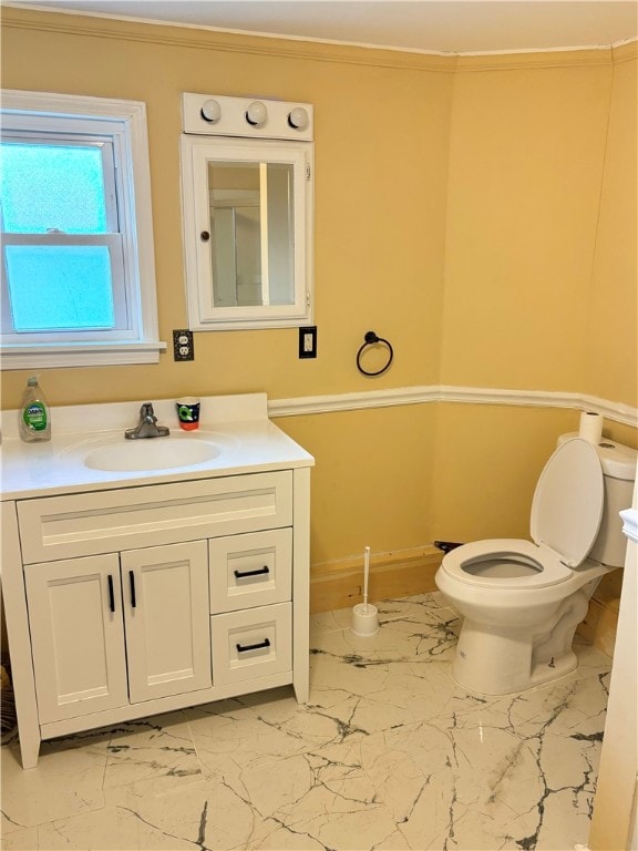 bathroom with vanity, toilet, and crown molding