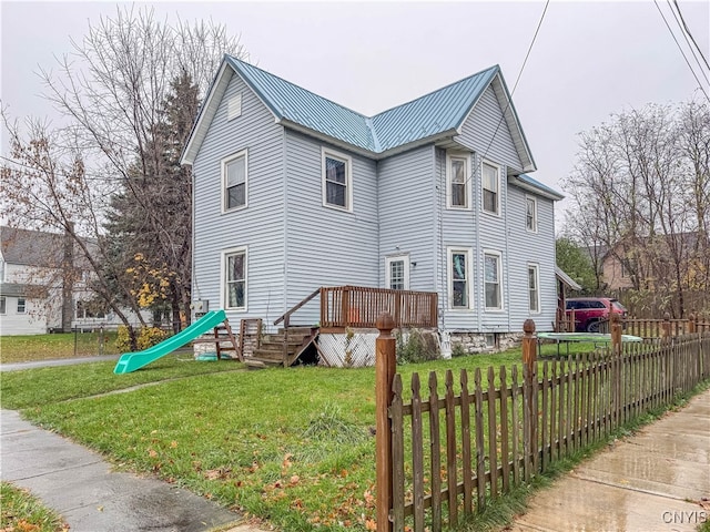 view of side of home with a deck and a yard