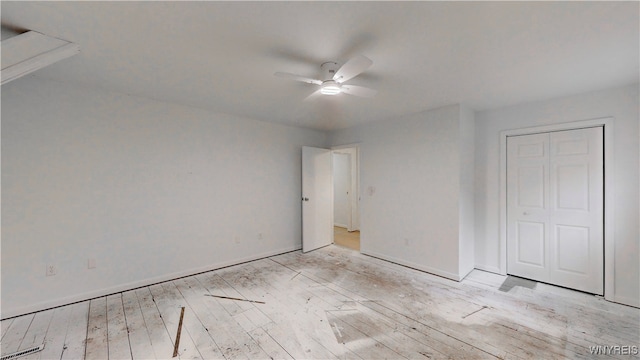 unfurnished bedroom featuring ceiling fan, light wood-type flooring, and a closet