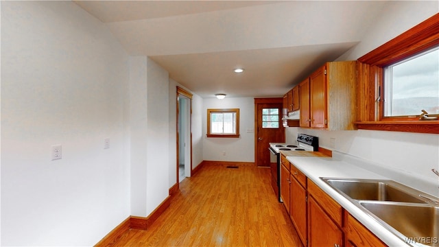 kitchen featuring lofted ceiling, sink, light wood-type flooring, white range with electric stovetop, and extractor fan