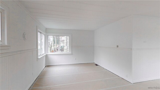 unfurnished room featuring wooden walls