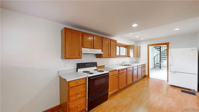 kitchen featuring light wood-type flooring, white appliances, and sink