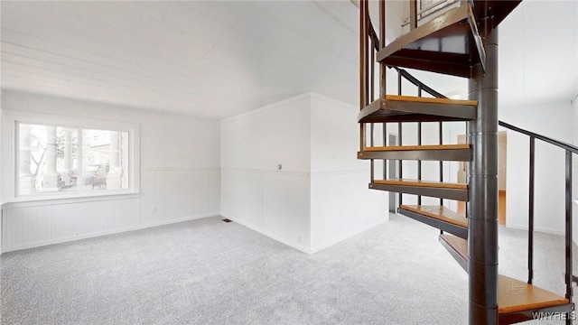 staircase featuring carpet